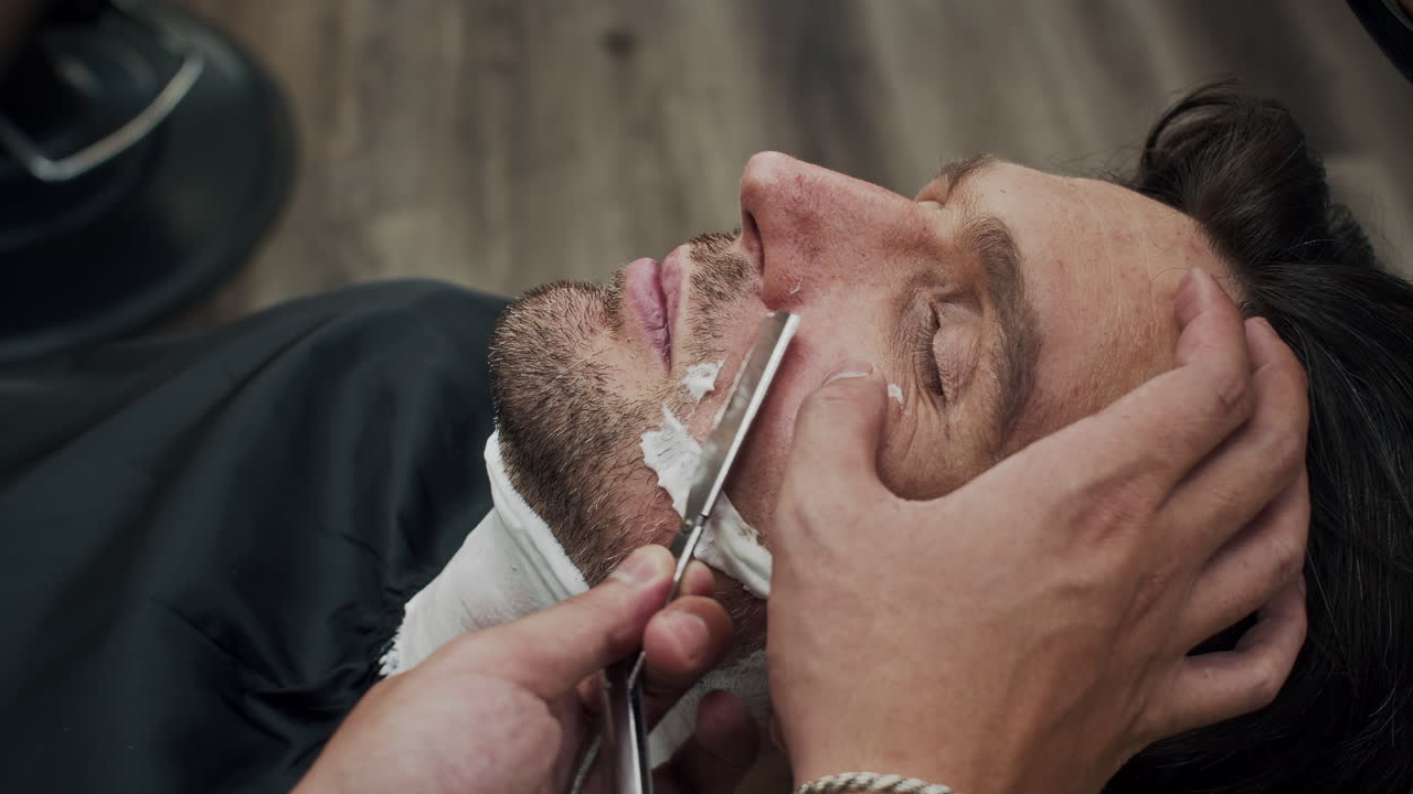 Un uomo che si fa la barba in un negozio da barbiere