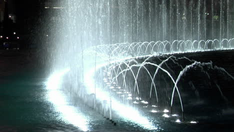 a large animated outdoor fountain shines at night