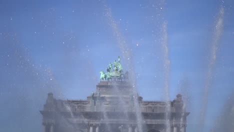 spraying fountain with the quadriga of the triumph arch in the background