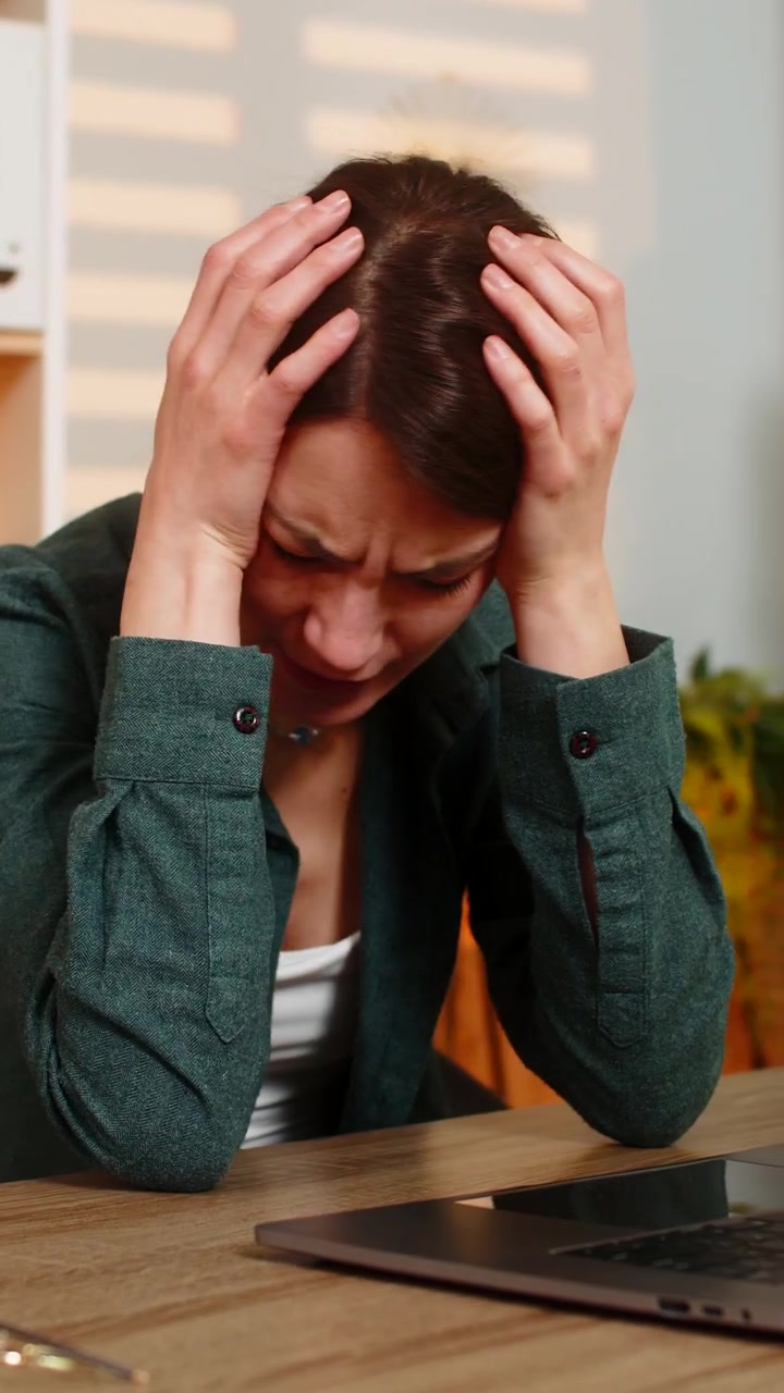 Young woman on home table reading bad news on laptop feeling upset and disappointed during work task