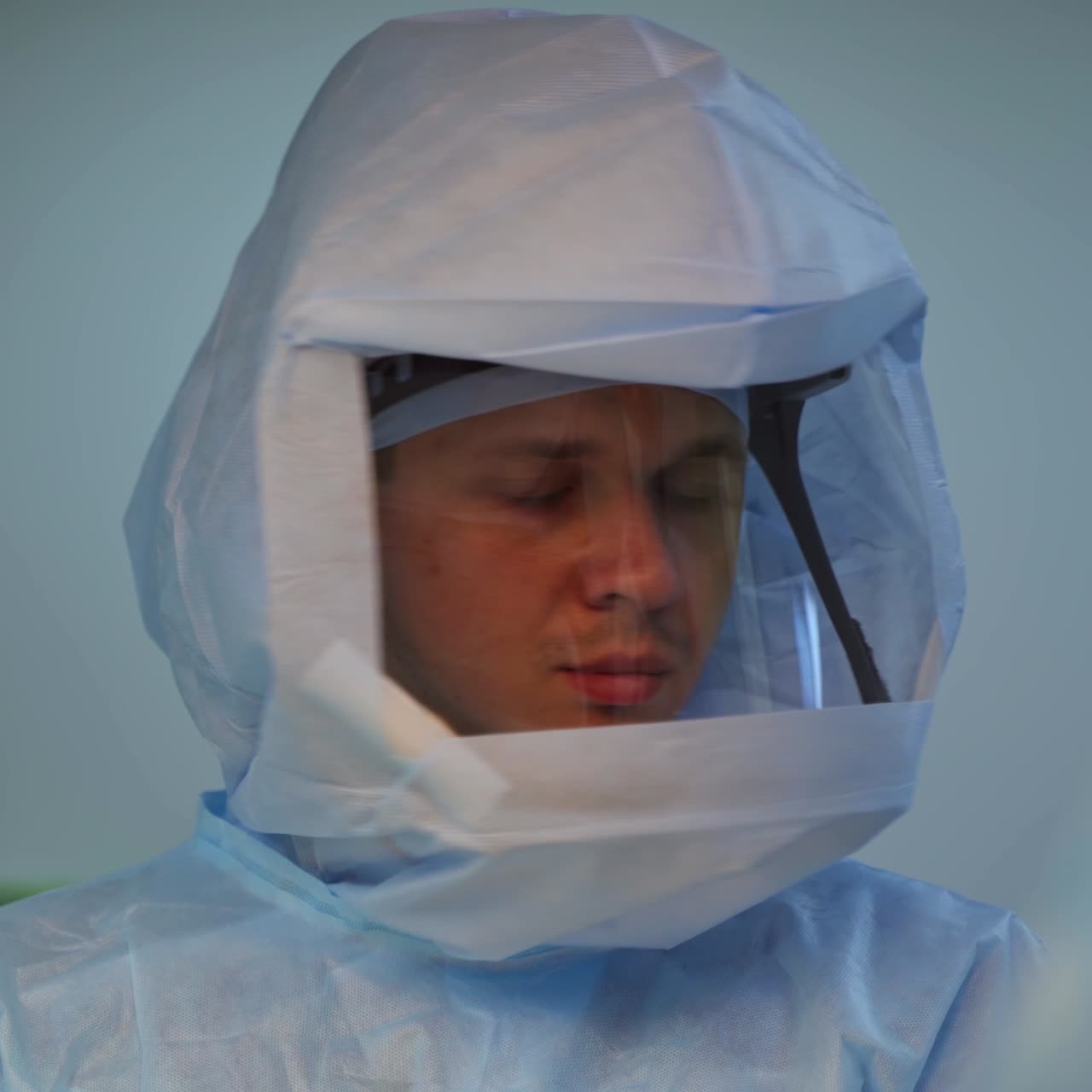 Medical worker in clinic. Portrait of young doctor in protective suit in the operating room. Face of experienced doctor in mask.