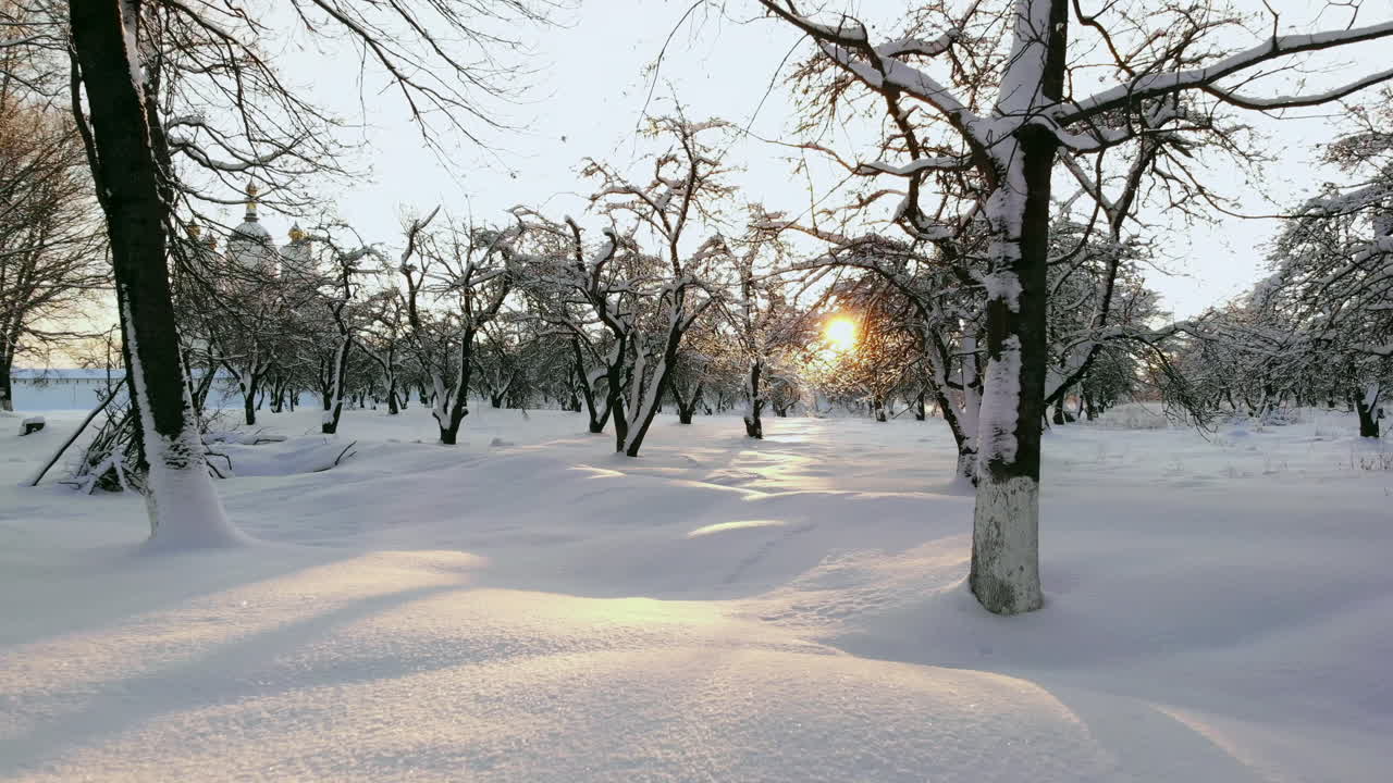 공중:황금빛 겨울 일출에 눈 덮인 숲을 운전하는 차 위로 날아갑니다. 겨울 도로 여행을 하는 사람들은 일몰 때 눈 덮인 라플란드 황야를 가로질러 여행합니다. 빈 얼음 도로를 운전하는 자동차