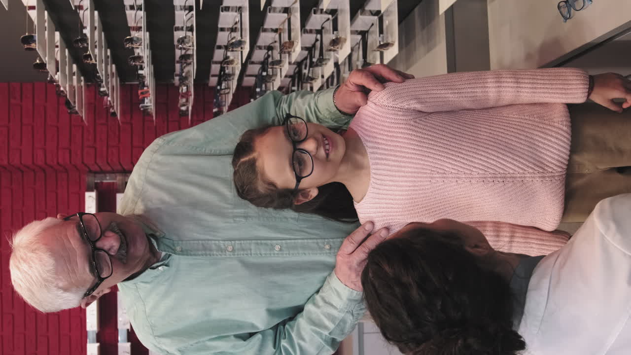 Little Girl Selecting Glasses At Optician