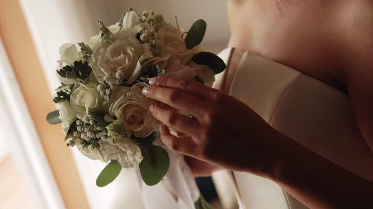 Close up of bride with elegant bouquet of white roses