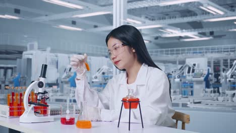 side view of asian woman scientist looking at test tube then thinking, looking around, and raising index finger in the laboratory with microscope, working in the lab analyzing samples test tube