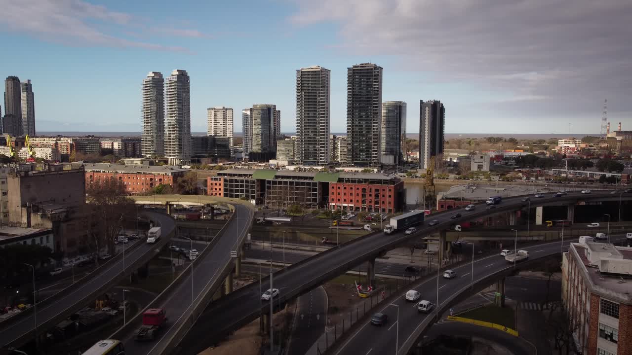 Aerial panoramic shot of traffic on highway intersection in Puerto Madero District of Buenos Aires during daytime - Skyline with skyscraper in background