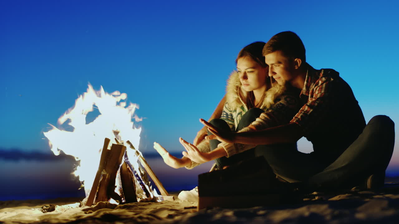 해변에서 휴식을 취하는 로맨틱 커플 그녀는 가을 햇살과 바람이 부는 날 남자에게 매달렸다