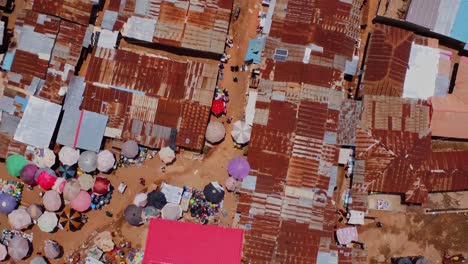 Top down aerial of a market in the rural town of Karshi, Nigeria. People walk through the small streets between the metal shacks on a sunny day