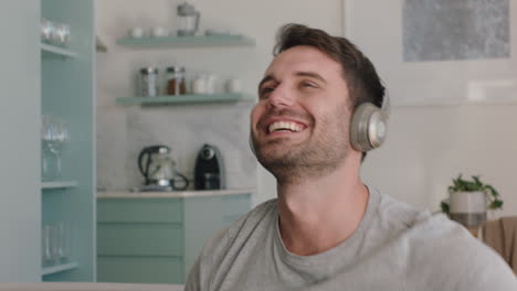 happy-young-man-singing-at-home-wearing-headphones-having-fun-listening-to-music-dancing-celebrating-freedom