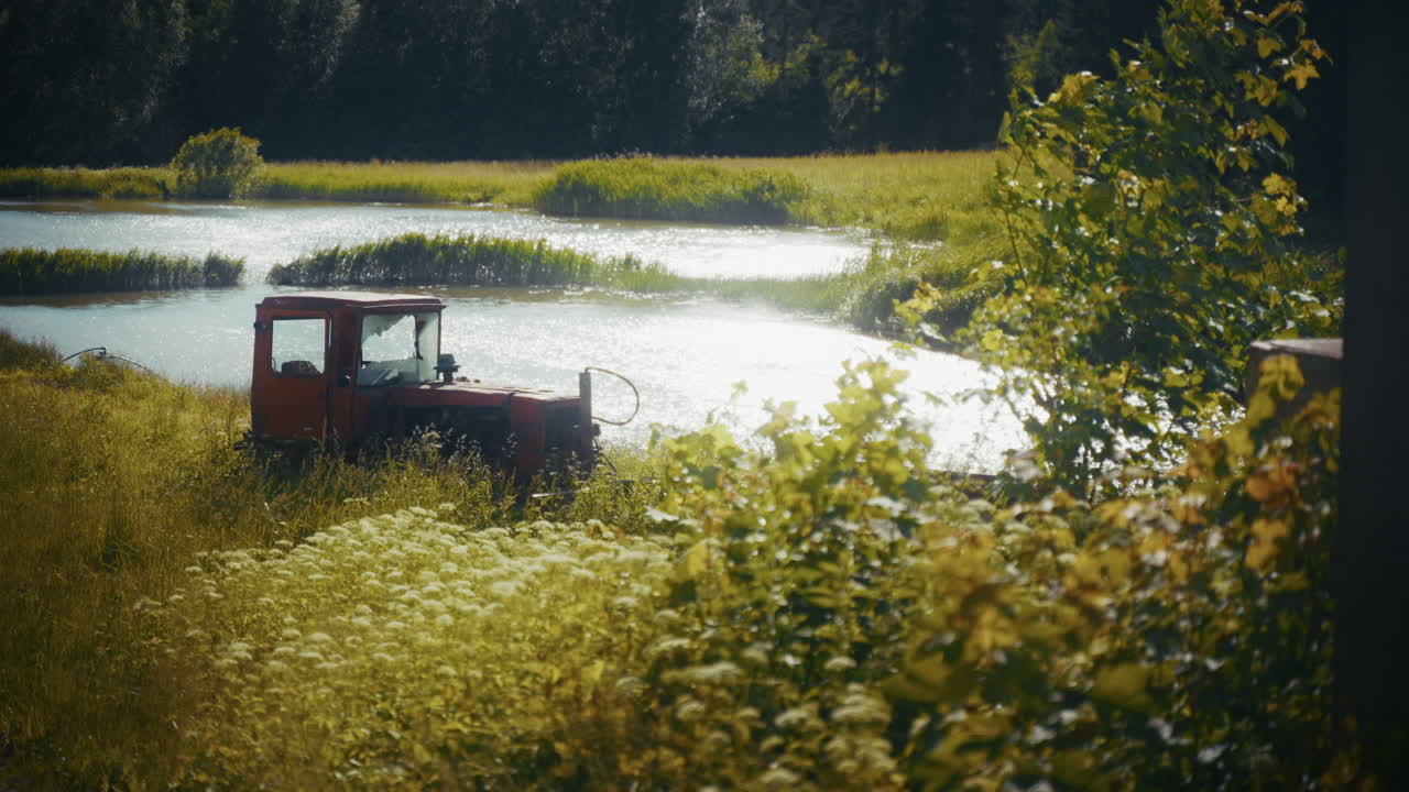 Red Tractor by a Pond in a Rural Landscape