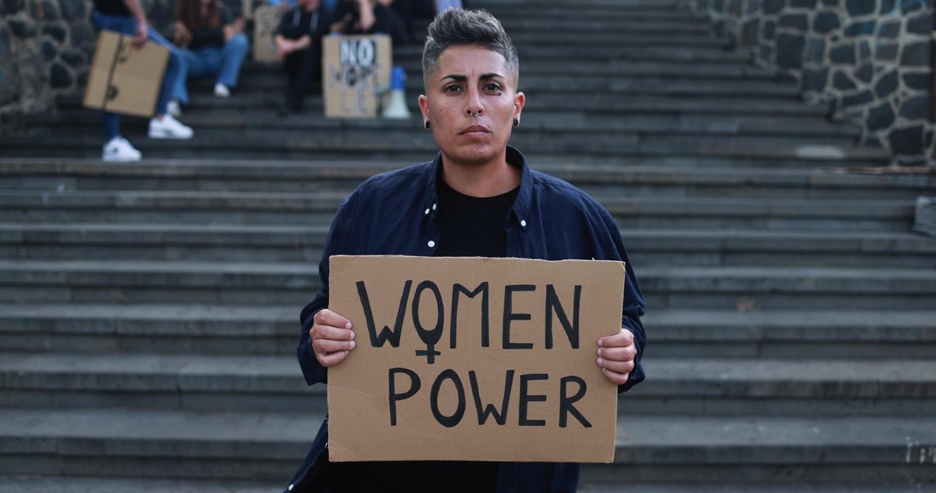 Aktivist hält 'Frauenpower'-Schild während einer Demonstration