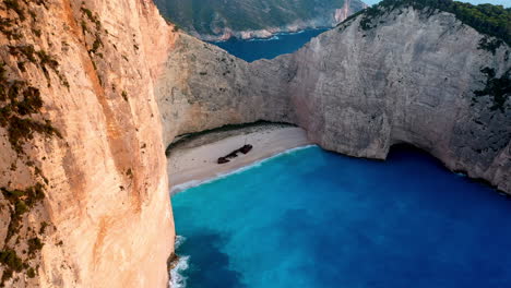 imágenes cinematográficas de drones de la playa de naufragios en la playa de navagio, mostrando los dramáticos acantilados y las aguas cristalinas