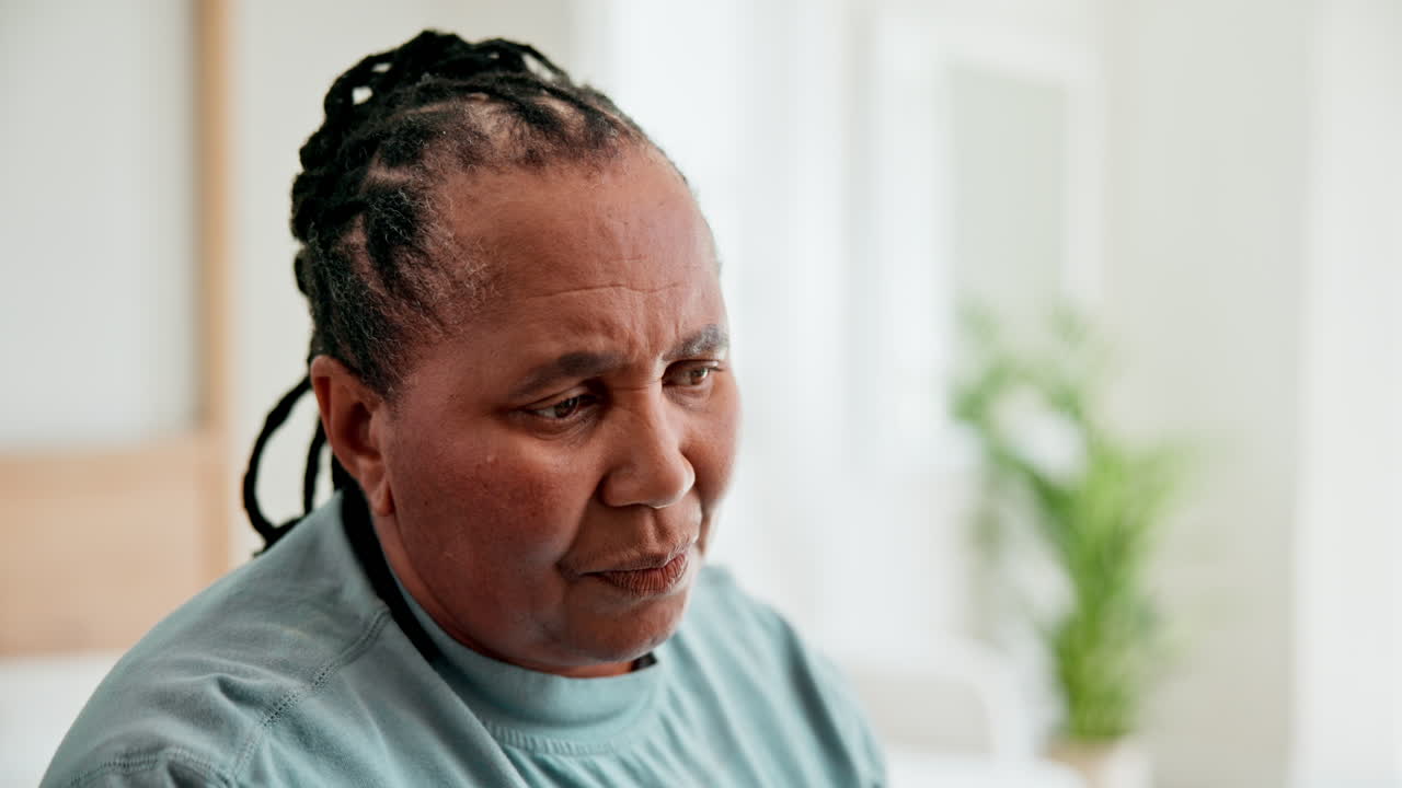 una mujer africana anciana, triste y pensativa.