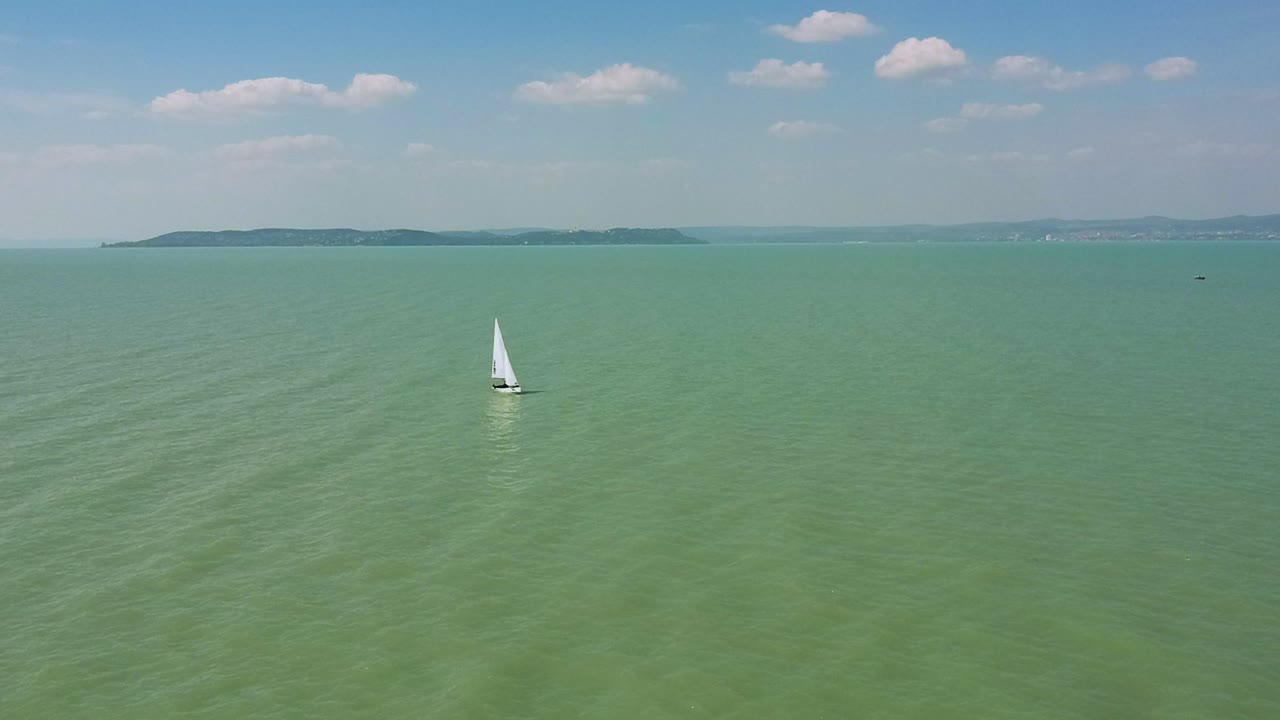 vista de drones por la tarde desde un pequeño velero cerca de la orilla de zamárdi, lago balaton
