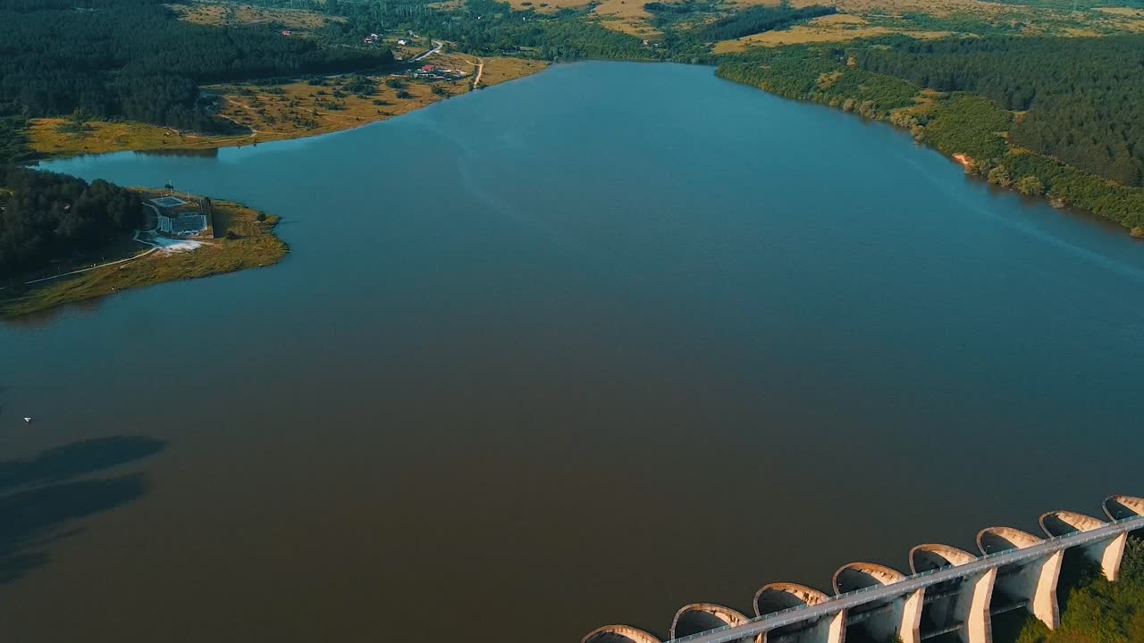 lago azul prístino creado por una larga presa utilizada para el riego disparo de dron