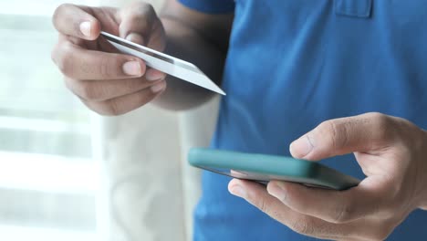 man using credit card and smartphone for online payment