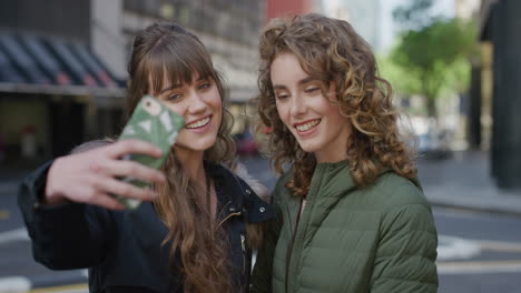 portrait of young women friends posing taking selfie photo using smartphone camera enjoying urban lifestyle together best friends hang out on city street real people series