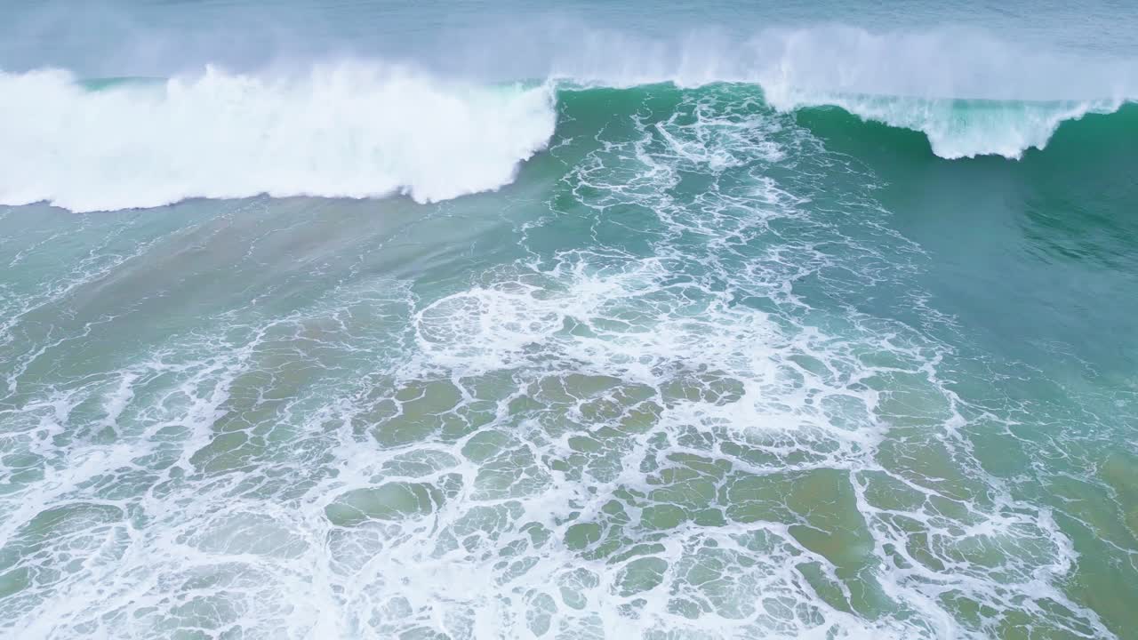 Waves crashing on the coast, aerial view of the ocean near Aljizur, Portugal