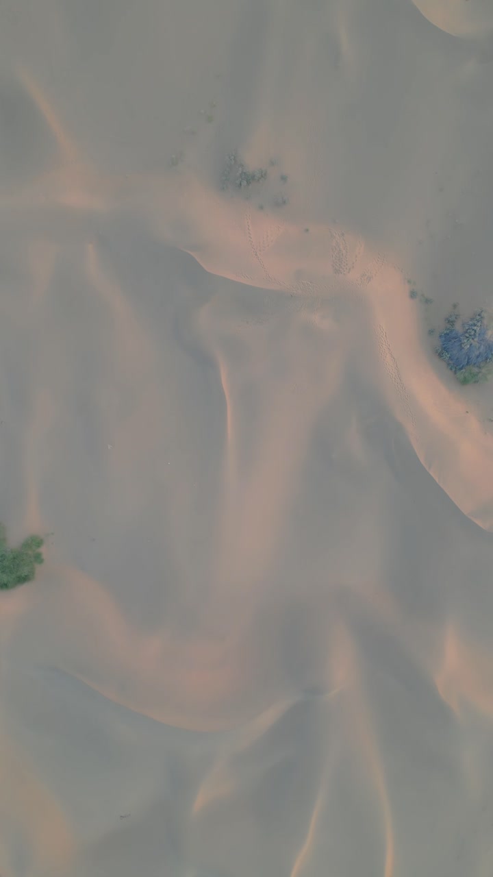 An aerial drone shot of mesmerizing sand dunes of Jaisalmer, Rajasthan, showcasing rippling patterns and the serene beauty of the vast Thar Desert in India 4K