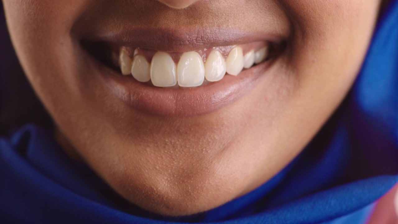 Close-up of a Woman Smiling Wearing a Blue Hijab