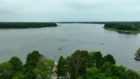 expansive aerial view of jeziorak lake, with sailboats drifting on calm waters, small islands, and a distant horizon, offering a perfect setting for nature and outdoor adventure