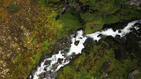 Cascada-Y-Río-A-Través-Del-Bosque-En-Una-Cadena-Montañosa-Desde-Arriba,-Noruega,-Europa,-Drone