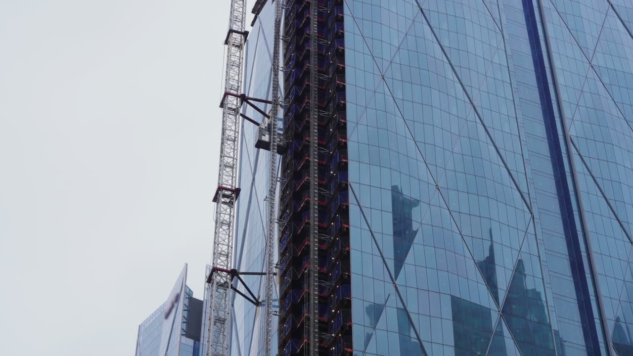 Construção moderna em um arranha-céu de vidro com elevador externo trabalhando em um novo projeto
