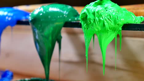 green and blue paint on the trowels are dripping