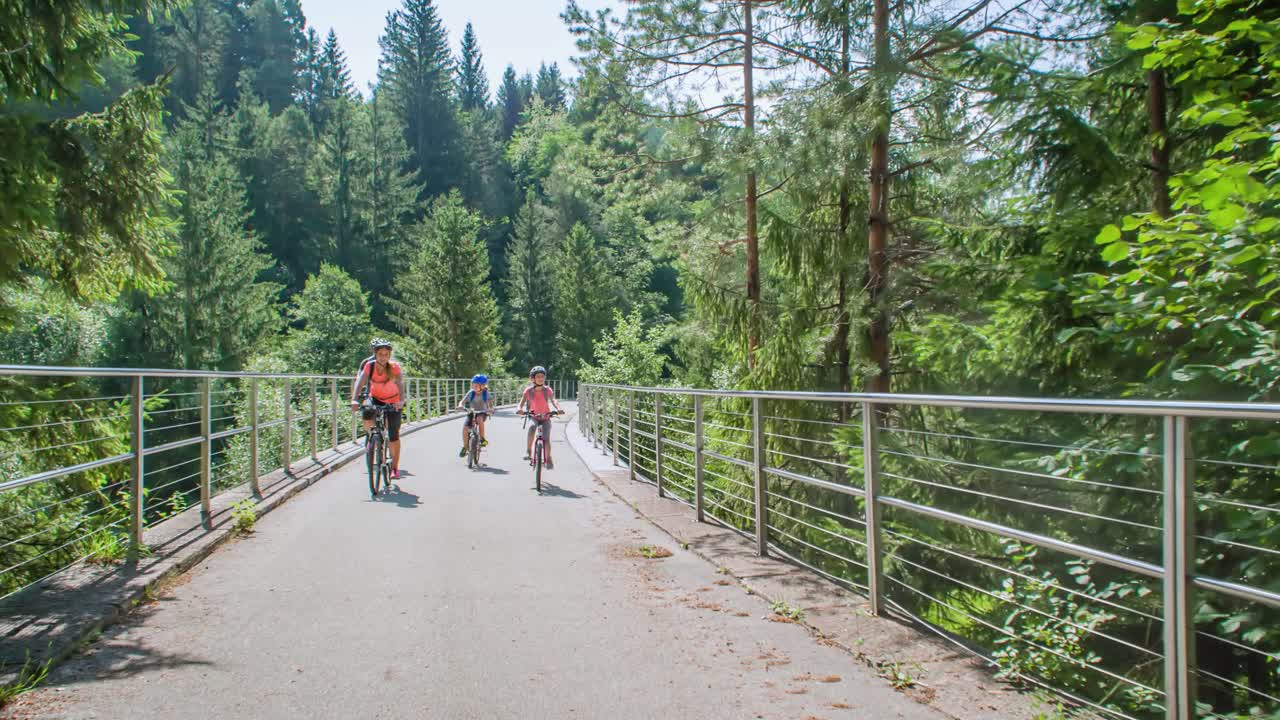 Active family of four cycling in nature Slovenia, tracking real-time