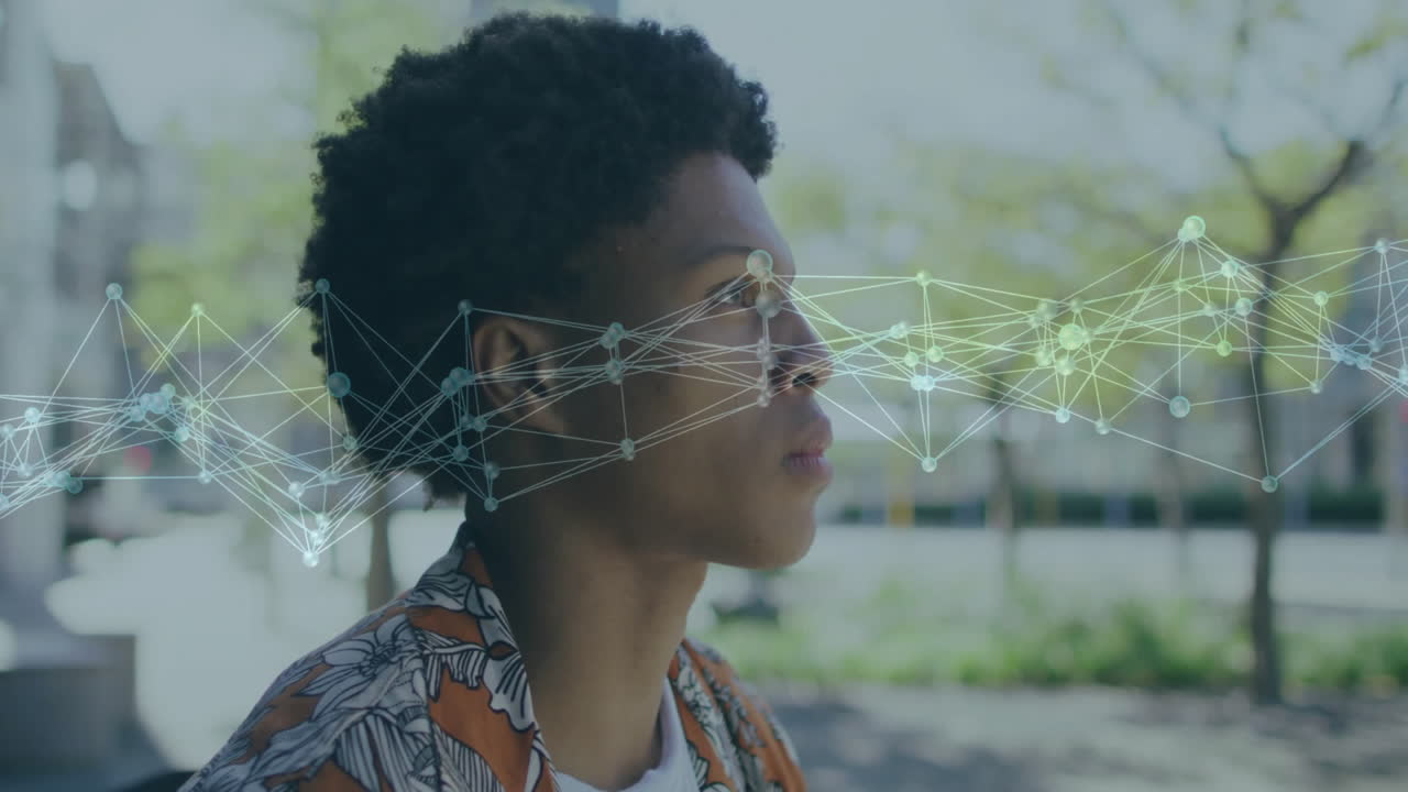Digital animation overlaying young man's profile outdoors with network connections