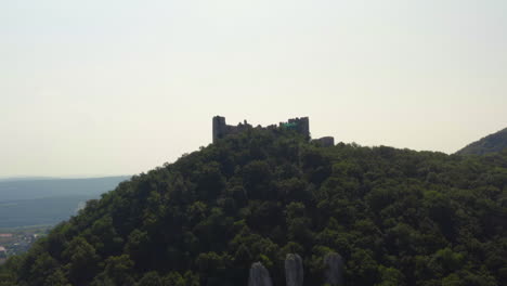 Ruins-of-Děvičky-gothic-castle-on-woody-hilltop-in-Moravia,-drone-shot