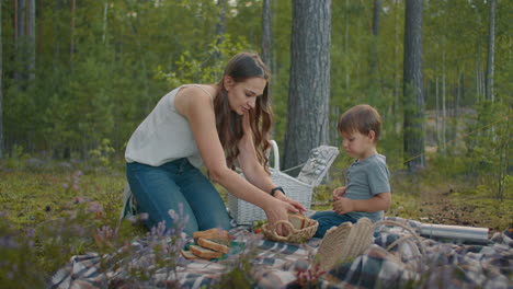 Familienpicknick-Im-Wald-Die-Junge-Mutter-Und-Ihr-Kleiner-Junge-Sitzen-Auf-Einer-Decke-Und-Bereiten-Am-Wochenende-In-Der-Natur-Essen-Zu