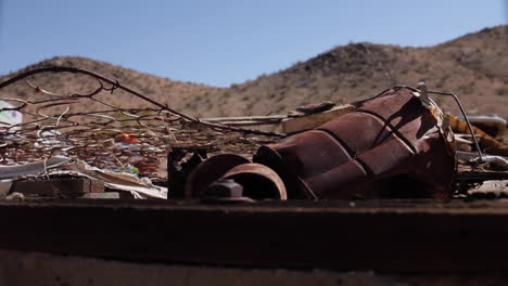 mountains in background as camera moves past trash in desert joshua tree