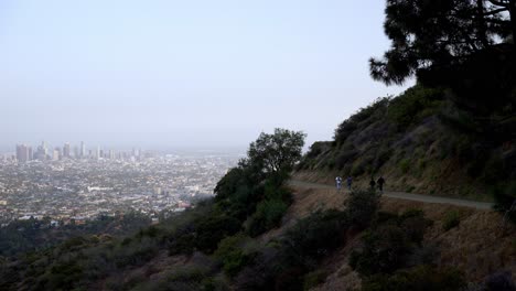 view of los angeles downtown and people hiking on the hills