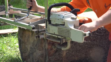 4k-clip-of-logger-in-orange-shirt-milling-a-log-as-the-chainsaw-breaks-through-the-end-of-the-log