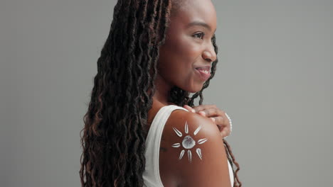 vrouw die zonnebrandcrème op haar schouder aanbrengt