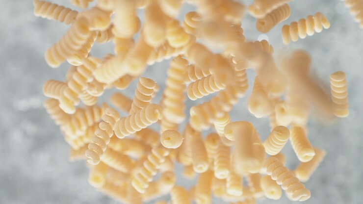 Spiralini Pasta Falling Into Pot Of Boiling Water Making A Splash In Slow Motion, Table Top View