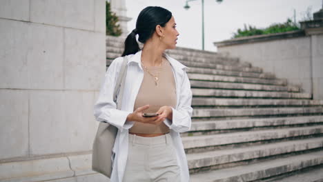 mujer nerviosa escribiendo teléfono móvil rápido vertical. chica latina sintiéndose perdida en la calle