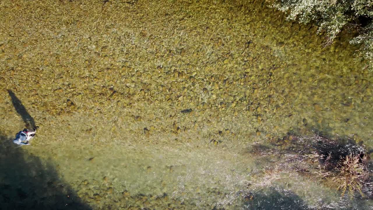 Pescatore a mosca che entra nell'inquadratura, lanciando la lenza
