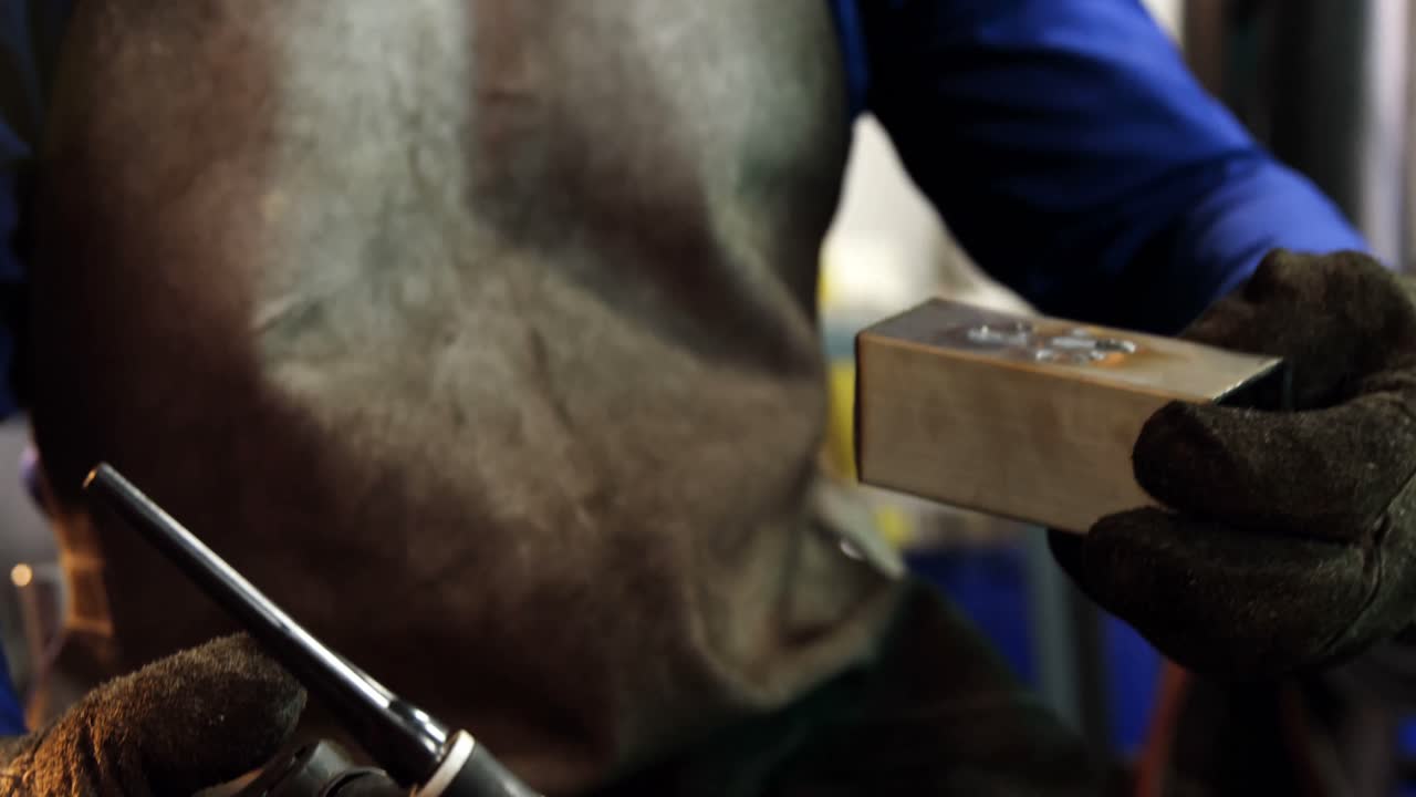 soldador masculino trabajando en una pieza de metal