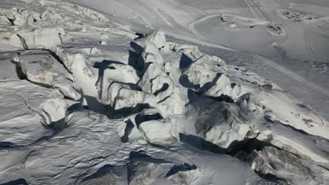 aerial view of a glacier, icy peaks and hidden crevasses in the swiss alps