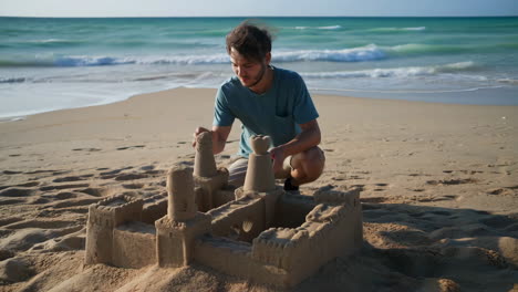 man building a sandcastle on the beach