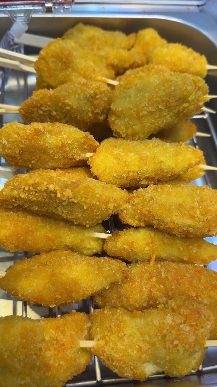 Close-up of Golden Fried Food Skewers on Display