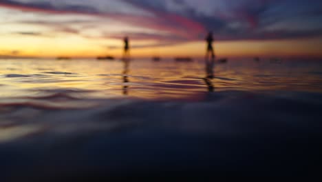 silhouettes on water at sunset