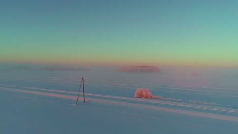 toma cinematográfica de un vasto paisaje cubierto de nieve fresca durante el amanecer, toma aérea