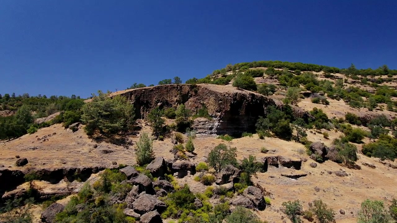Elokuvallista drone-kuvaa Richard Springsin Calvary Cross -rististä, YWAM Chico, Upper Bidwell Park, Butte Cave Creek Canyon, Kalifornia, aurinkoisena keskipäivänä, kiertävä liike