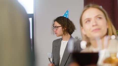 happy young man drinking champagne and talking with a colleague at the office party