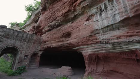 Weathered-stone-rock-walls-with-brick-and-concrete-archway-built-into-side-of-mountain