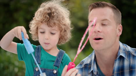 Vater-Und-Sohn-Blasen-Gemeinsam-Seifenblasen-Im-Sonnigen-Park.-Süßer-Kleiner-Junge,-Der-Spaß-Hat.-Vater-Spielt-Mit-Kind-Und-Genießt-Spielerisch-Den-Sommer-4k