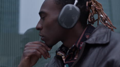 black man with goatee looks around and stares on his reflection in window
